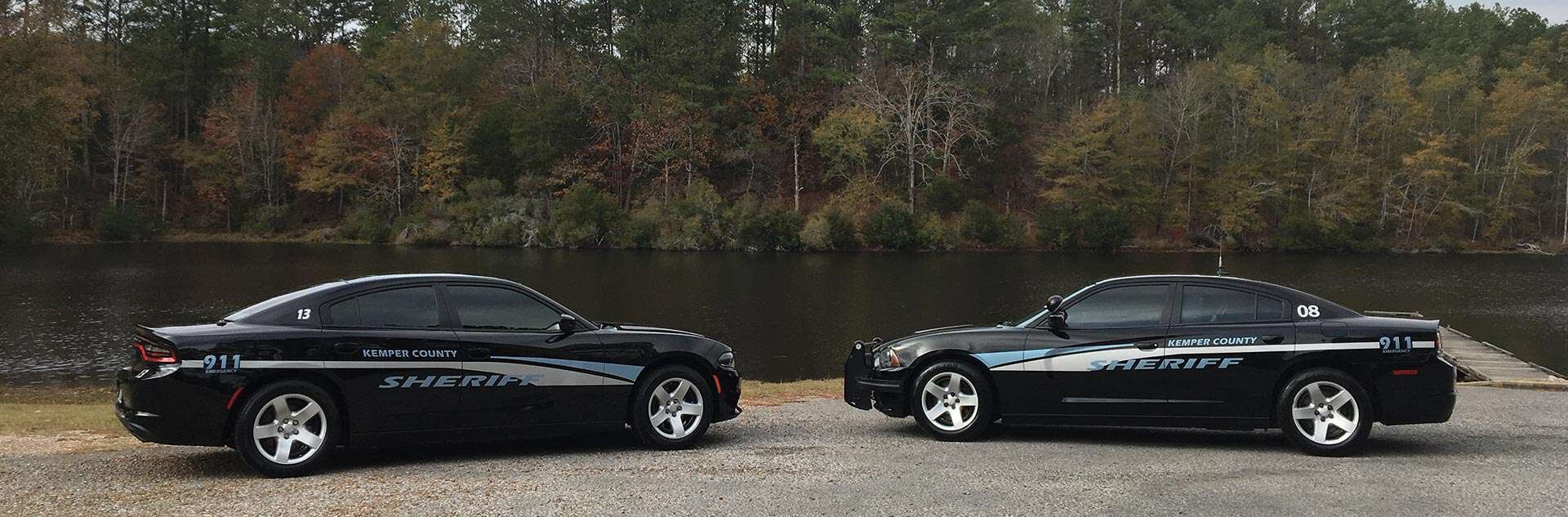 Two Kemper County Sheriff's Office patrol vehicles in front of a river